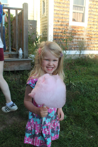A smiling child holding fresh pink cotton candy at a previous Bean family Oktoberfest